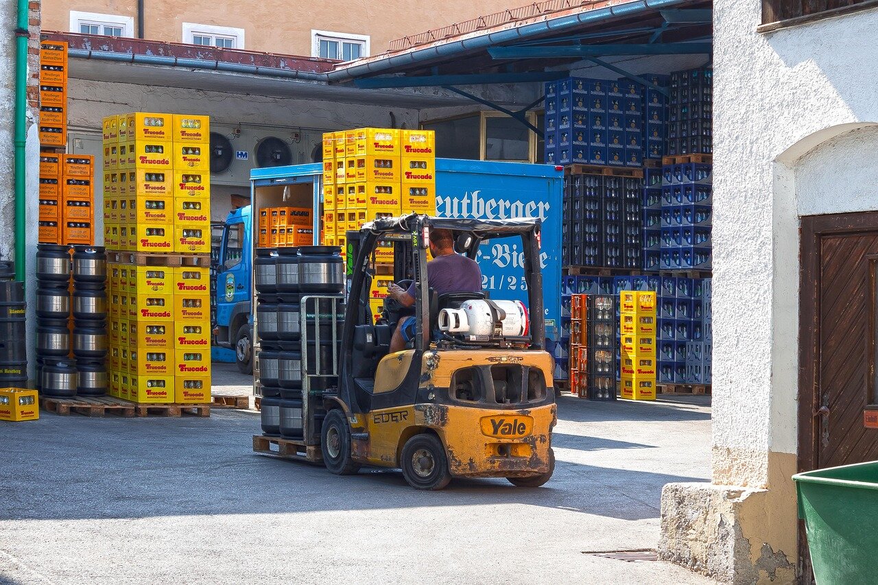 Forklift operator moving pallets on a job site